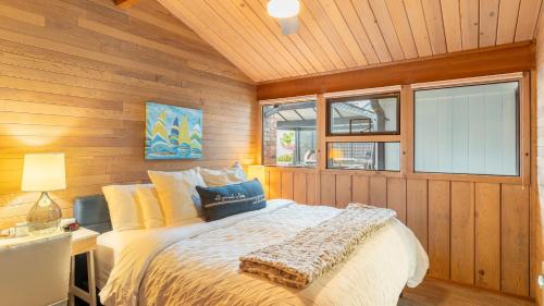 a bedroom with a bed in a wooden wall at Oceanfront w Game Room Fire Pit Panoramic Views Angels Landing by AvantStay in Langley