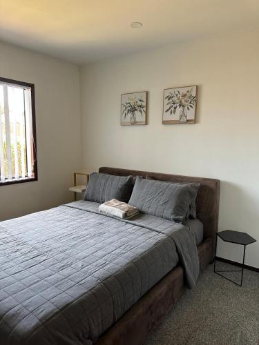 a bedroom with a bed with a blue blanket at Carnoustie Calm- A Cosy Wattle Downs Home in Auckland