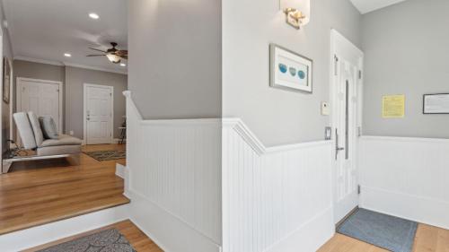 a hallway with white walls and a staircase with a chair at 3800 Cameron Boulevard AvantStay Pool Ocean Views Deck in Isle of Palms