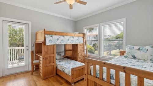 a bedroom with a bunk bed and two windows at 3800 Cameron Boulevard AvantStay Pool Ocean Views Deck in Isle of Palms