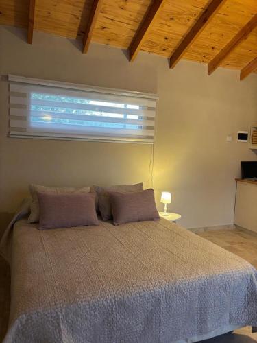 um quarto com uma cama grande com janela em Patagonia Nido em Trevelín