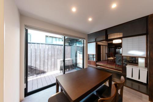 アトレチア祇園宇治別邸プレミアム في يوجي: غرفة طعام مع طاولة ونافذة كبيرة