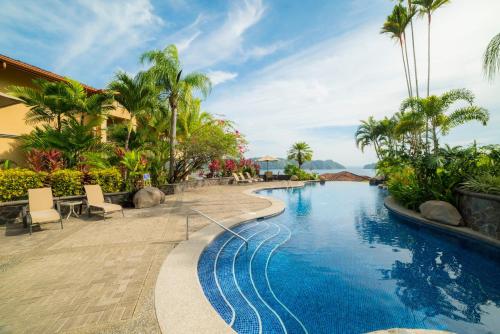 una piscina in un resort con palme di Marbella 1E 3 BR Ocean View a Isla Herradura