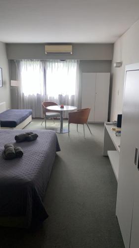 een hotelkamer met 2 bedden, een tafel en een eetkamer bij El rejunte , CABA in Buenos Aires