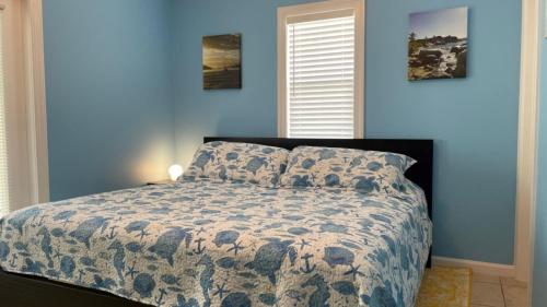 Coral Garden by AvantStay Great Location w Balcony Shared Pool في ستوك آيلاند: غرفة نوم بها سرير وجدار أزرق