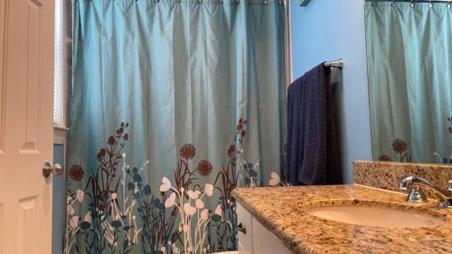 Coral Garden by AvantStay Great Location w Balcony Shared Pool في ستوك آيلاند: حمام مع مغسلة وستارة دش