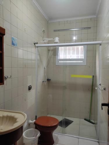 a bathroom with a shower with a toilet and a sink at Casa Praia Arpoador in Peruíbe