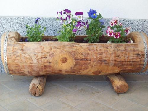 a wooden planter with flowers in it at B&B Nido Delle Aquile in Monclassico