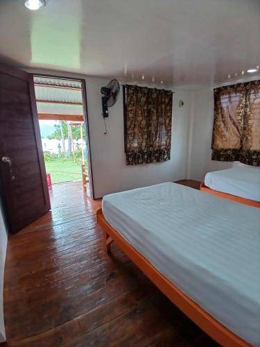 a bedroom with a large bed and a window at Pamilacan Vacay in Baclayon