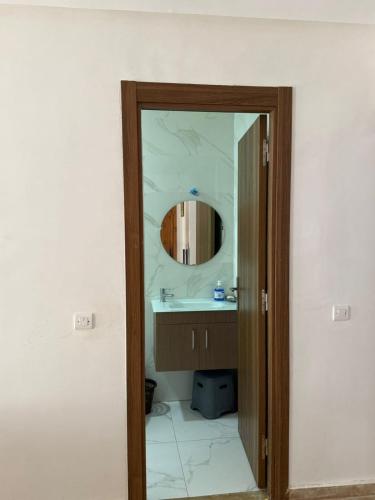 a bathroom with a mirror and a sink at 2BR Beach Apt, Pool, Luxury place in Mansouria