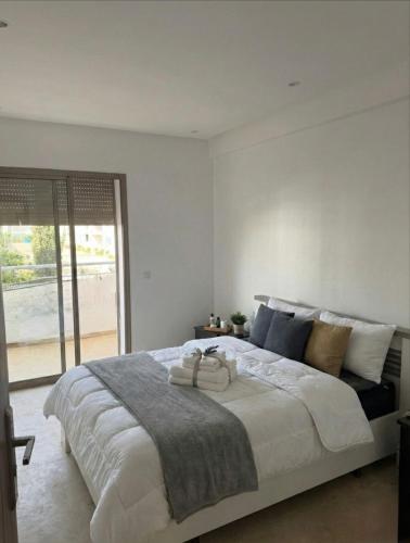 a bedroom with a large bed and a large window at 2BR Beach Apt, Pool, Luxury place in Mansouria
