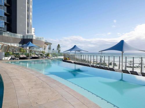 Peppers Soul Surfers Paradise في غولد كوست: مسبح مع مظلات والمحيط