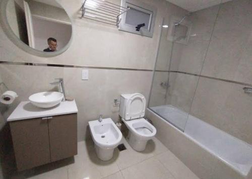 ein Badezimmer mit Toilette, Waschbecken und Spiegel in der Unterkunft Hostel Suite DDT in Santa Fe