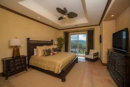 een slaapkamer met een bed en een flatscreen-tv bij Montebello 1C - 3 bdr 3 bath Ocean view in Isla Herradura