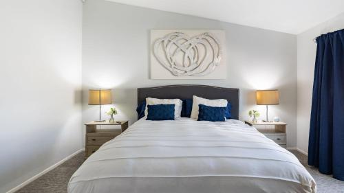 a bedroom with a large bed with blue curtains at Pacifica Sur by AvantStay Pool Hot Tub Gazebo in Indio