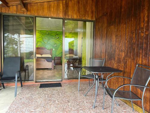a room with a table and chairs and a bedroom at Little Paradise in Nuevo Arenal