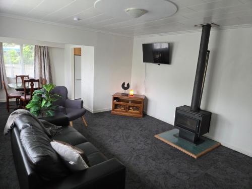 a living room with a couch and a wood stove at Accessible Respite House in Whangarei