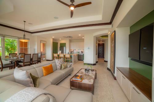 uma sala de estar com um sofá branco e uma TV em Terrazas 1A - 3 bedroom - seven day minimum em Isla Herradura