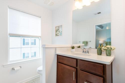 a bathroom with a sink and a toilet and a mirror at Glam Family Funhouse NYC Access Adventure in Fair Lawn