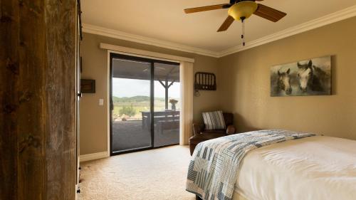 a bedroom with a bed and a ceiling fan at Olive Ranch by AvantStay Enjoy Sunsets over the Valley 4.5 Acre Ranch Home in Paso Robles
