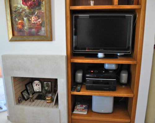 ゲラニにあるGerani Private Villaの暖炉付きの本棚のテレビ