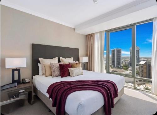 a bedroom with a large bed with a large window at Stunning Oceanview - Beachfront hotel suite in Gold Coast