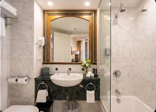 a bathroom with a sink and a mirror and a shower at Stunning Oceanview - Beachfront hotel suite in Gold Coast