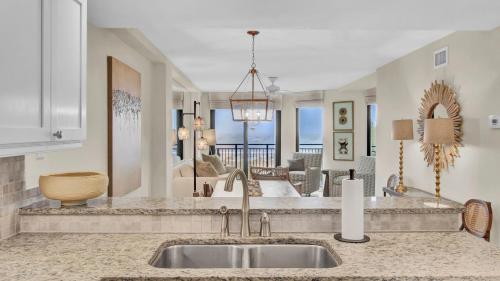 Una cocina con fregadero y una sala de estar. en 303A Shipwatch by AvantStay Ocean View Shared Pool Boardwalk to Beach, en Isle of Palms