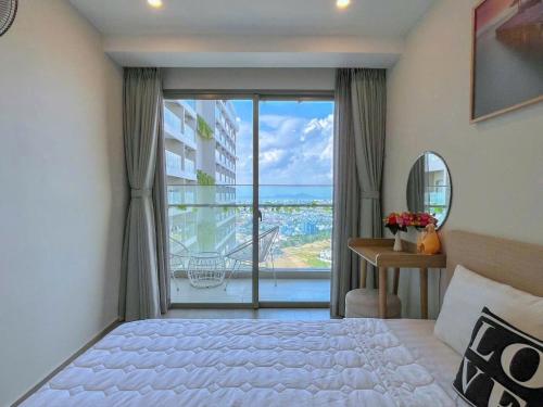 a bedroom with a bed and a large window at The Sóng Vũng Tàu Apartment in Vung Tau