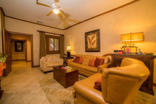 uma sala de estar com sofás e um ventilador de teto em Veranda 1E 3bdr 3 bath em Isla Herradura