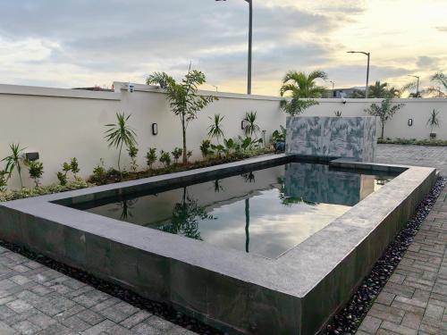 una piscina d'acqua in mezzo a un cortile di Les Champs Beau Vallon a Mahébourg