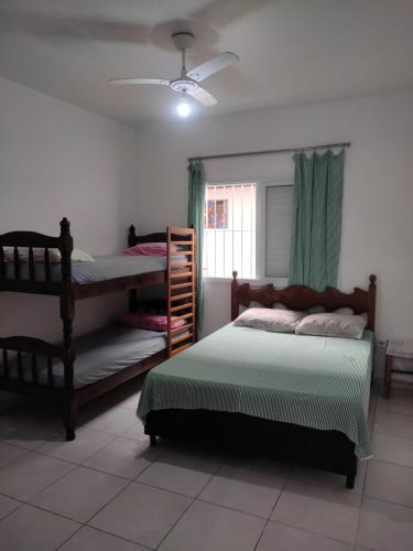 a bedroom with two bunk beds and a window at Casa Praia Arpoador in Peruíbe