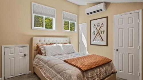 a bedroom with a bed and two windows at Slopeside Escape by AvantStay Walk to Ski Lifts Arcade Games Shuffleboard in Tannersville