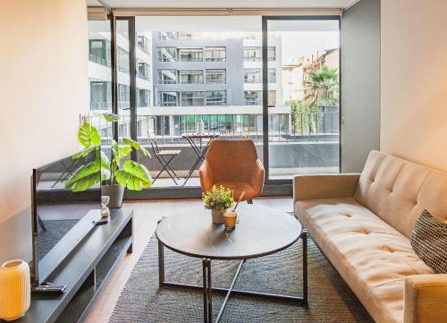 a living room with a couch and a table at HOM I Lujoso Depto 2D2B, Ñuñoa con Estacionamiento in Santiago