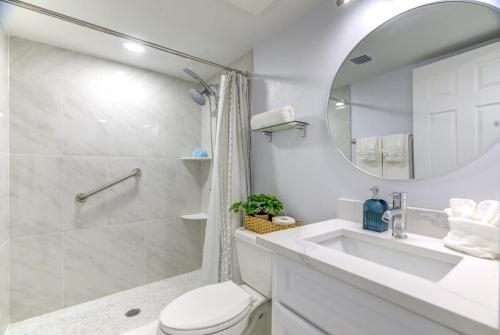 een badkamer met een toilet, een wastafel en een spiegel bij Madeira Norte Beachfront Condo - Walk To John's Pass in St Pete Beach