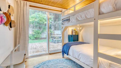a bedroom with a bunk bed and a large window at Four Bears by AvantStay Walk to Beach Hot Tub Ocean View in Arch Cape