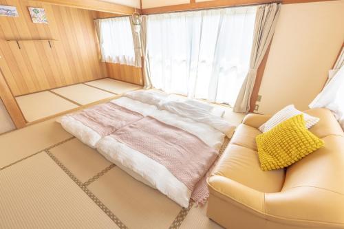 a living room with a couch and a bed at よんなーハウス in Kameoka