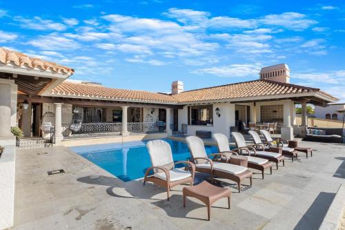 a group of chairs sitting next to a swimming pool at Casa Brooks in Cabo San Lucas