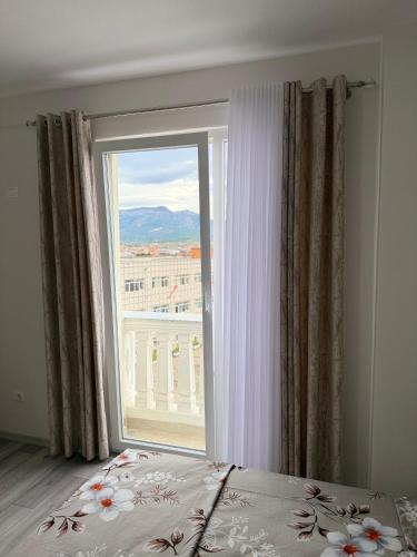 Modern 2-Bed Near Tirana and Airport with Balconies في Kamëz: غرفة نوم مع نافذة كبيرة مطلة