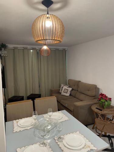 a living room with a table and a couch at Mar e sol residencial 2 quartos com ar condicionado,500 metros da praia de Jacumã in Conde