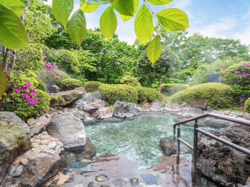 a pool of water with rocks in a garden at Grand Mercure Nasu Highlands Resort & Spa in Nasu
