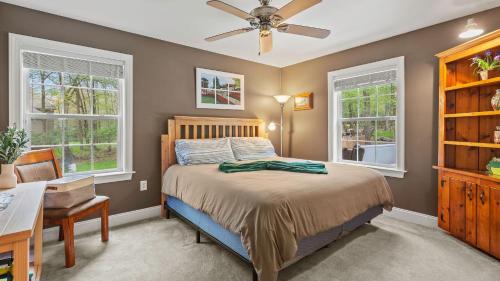 1 dormitorio con 1 cama, ventilador de techo y ventanas en Chalet on Chalet by AvantStay Bright Cabin w Deck Fire Pit Near Lake, en Lake Harmony