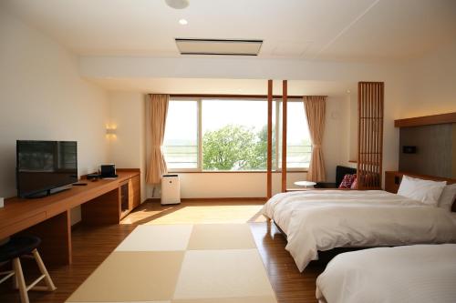 a bedroom with a bed and a desk and a television at Kangetsuen in Otofuke