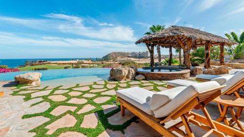 uma piscina com cadeiras e um pavilhão com vista para o oceano em Casa Mar em El Tule