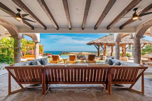 um pátio exterior com um sofá, mesas e cadeiras em Casa Mar em El Tule