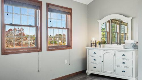 Lakers Pointe by AvantStay Lakefront Private Peninsula Hot Tub Game Room في Long Pond: غرفة بها خزانة بيضاء ونوافذ