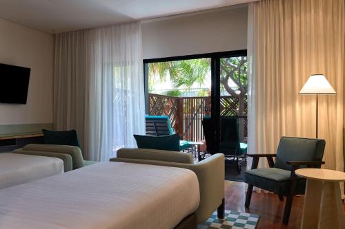 a hotel room with two beds and a large window at Pinctada Hotel Broome in Broome