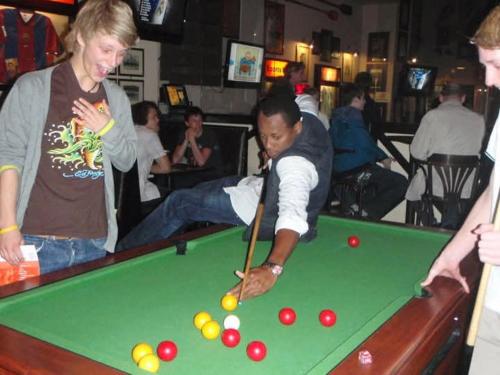 a man playing pool with a cue on a pool table at Rolando share apart in Punta Cana