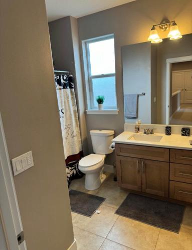 a bathroom with a toilet and a sink and a mirror at Home in Vancouver in Vancouver