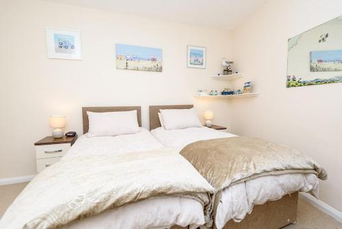 twee bedden in een slaapkamer met witte muren bij Heart of Looe Apartment in Looe